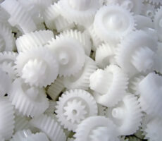Bulky white plastic gears ready for sorting or for assembly